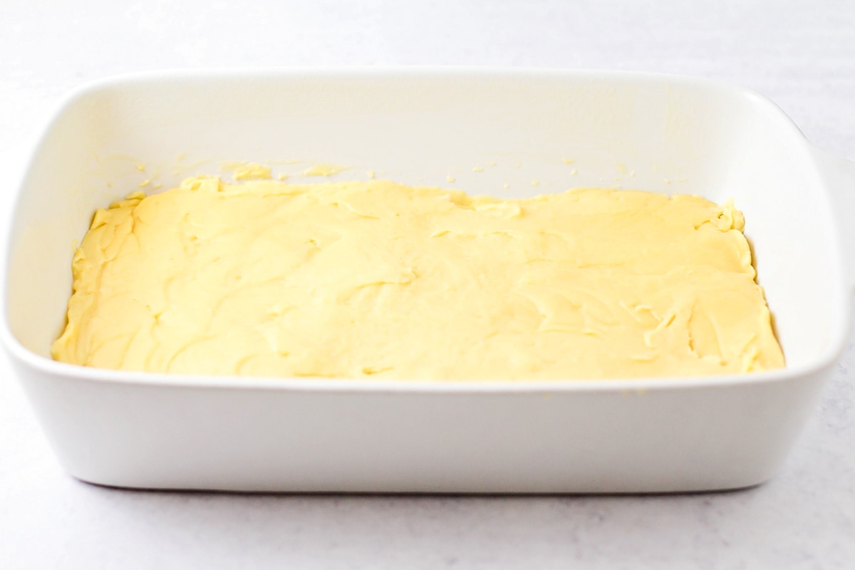 将奶油泡芙蛋糕的面团放在烤盘底部。