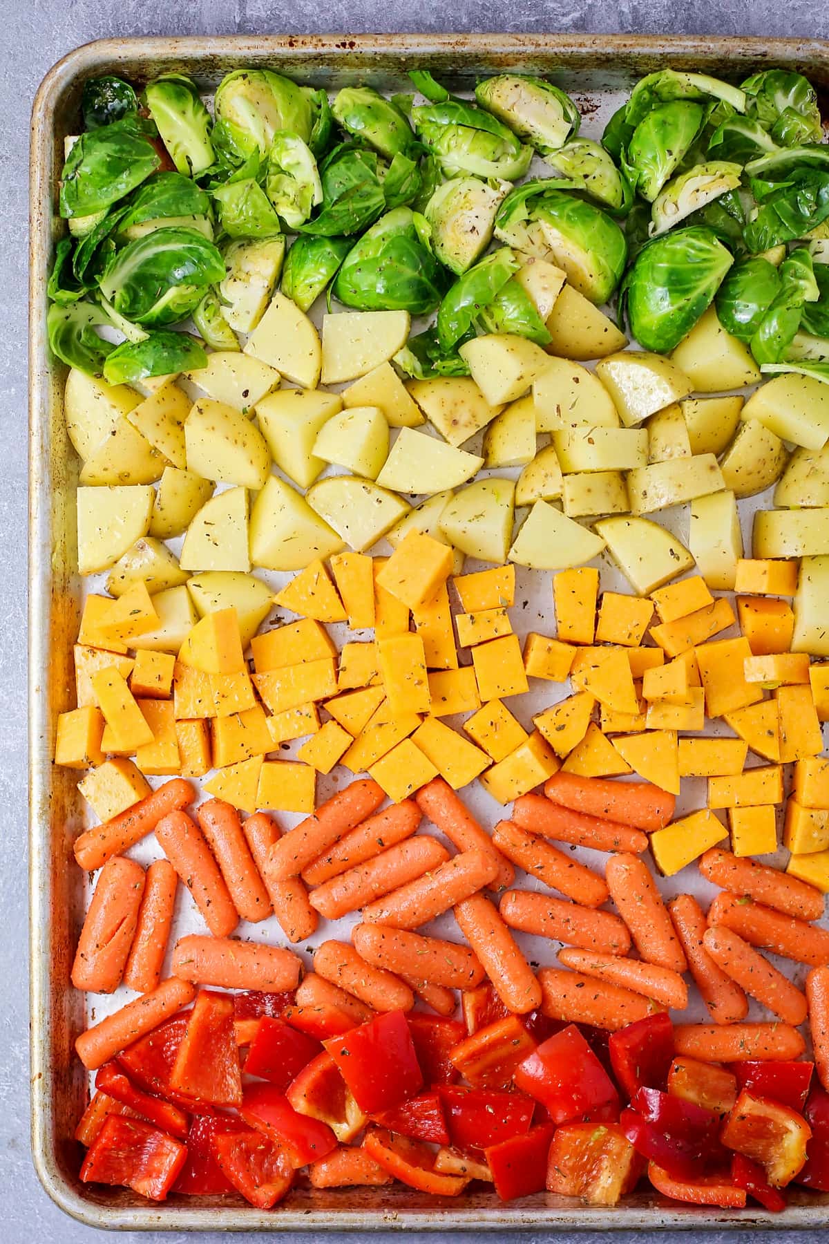 将烤好的蔬菜按彩虹顺序放在烤盘上准备烘烤。