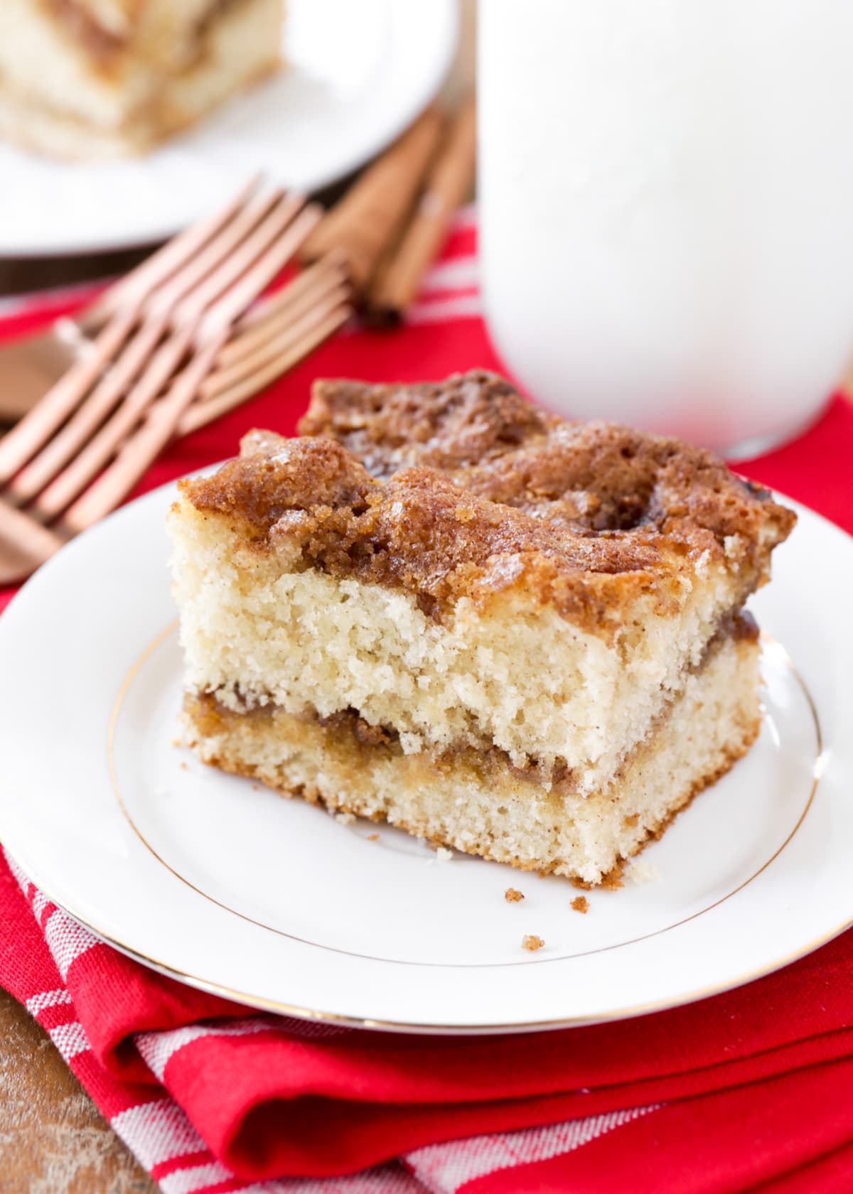Coffee cake recipe slice on white plate with red dish towel.