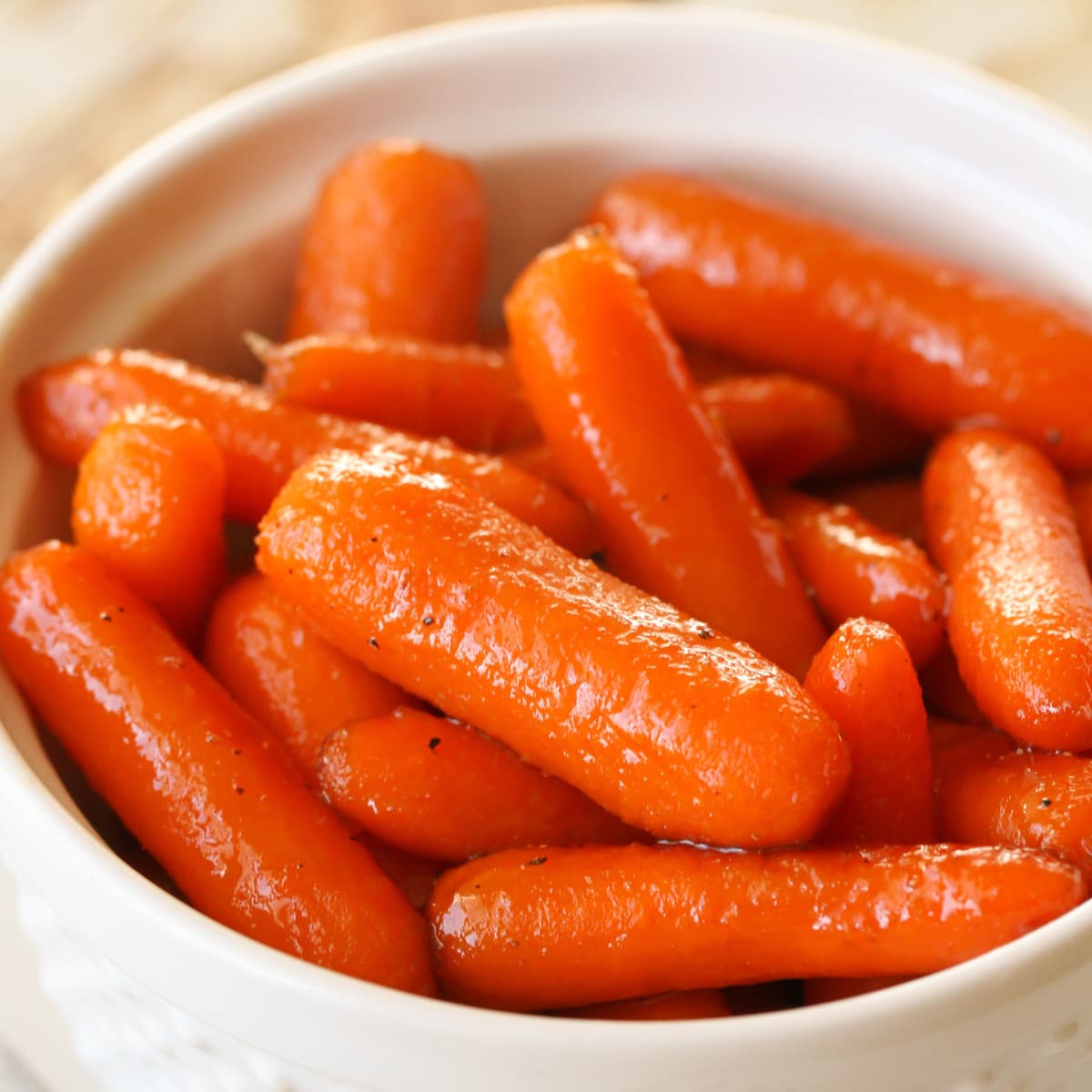 红糖上釉的胡萝卜装在白碗里。