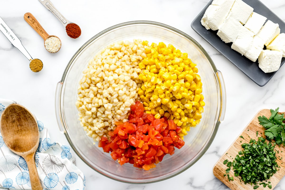 A bowl filled with ingredients for hot corn dip.