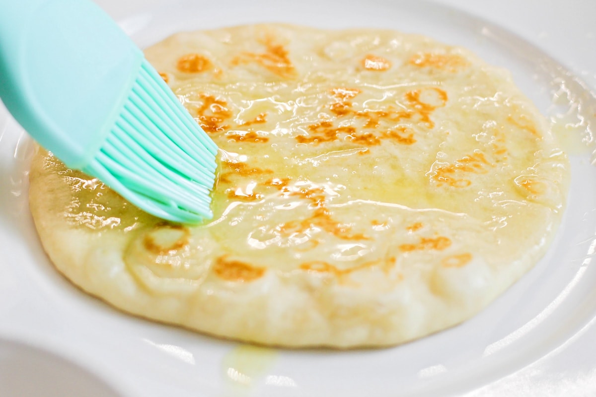 融化的黄油涂在自制的馕饼上。