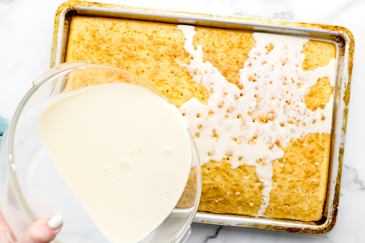 用蛋糕粉将牛奶混合物倒在烤好的三乳蛋糕上。