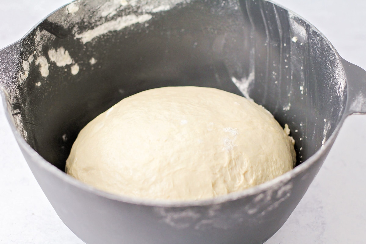 自制意大利辣香肠披萨的面团在灰色的碗里发酵。