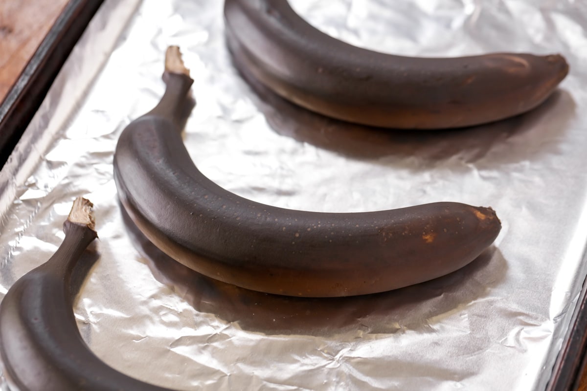 深色熟香蕉放在有衬里的烤盘上。